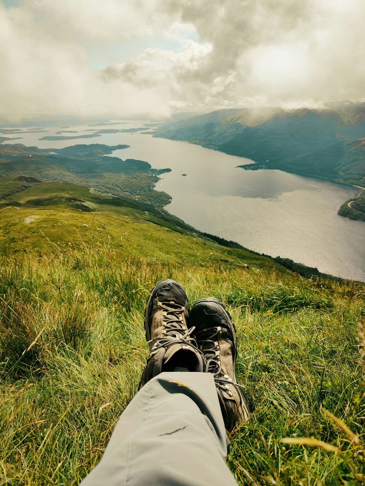 Hiking boots resting on a grassy hilltop overlooking a loch — walking for weight loss outdoors