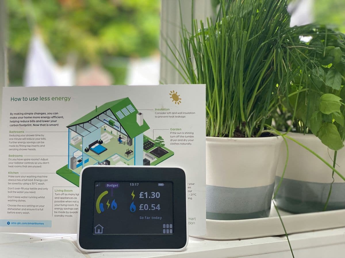 Smart energy meter showing daily costs next to energy saving tips — cutting household bills