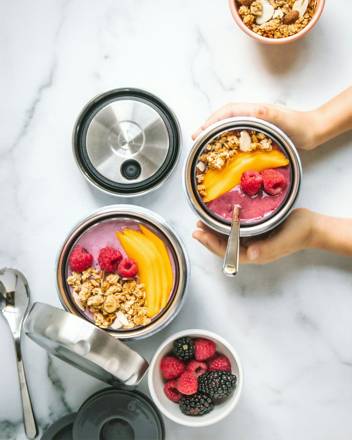 Smoothie bowls with granola, mango and berries in insulated containers — quick high-protein breakfast